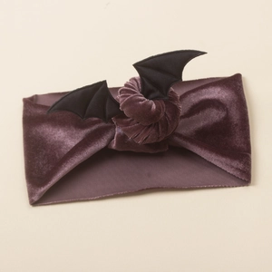 Detail of soft purple velvet baby headband featuring black Halloween bat wings decoration