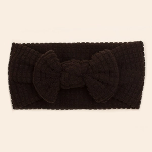 Close-up of deep brown waffle knit baby headband with a large decorative soft bow