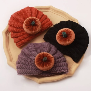 Three pumpkin-themed baby knitted hats in orange black and purple for Halloween style