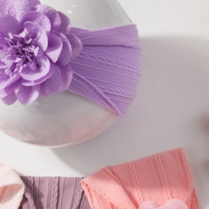 Détail de bandeaux tricotés pour bébé avec de grandes fleurs en tissu de couleurs variées