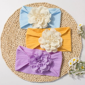 Bandeaux élastiques à fleurs pour bébés en bleu clair, jaune et violet sur tapis