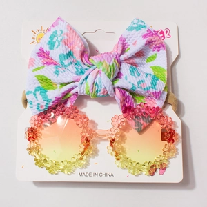 Detail of floral baby headband and flower sunglasses set on a white display card