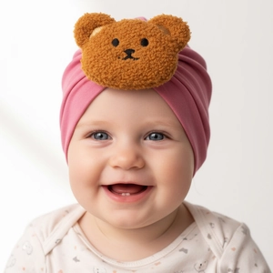 Close-up of pink baby turban hat with a plush brown bear head and soft knit fabric