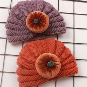 Detailed knit texture of Halloween pumpkin baby beanie with velvet top decoration