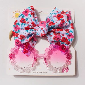 Detail of pink flower sunglasses and floral bow headband set for baby girls
