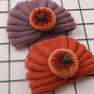 Detailed close-up of knitted baby turban hats with velvet pumpkin topper for Halloween