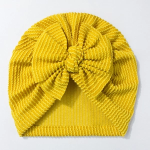 Close-up of bright yellow newborn turban hat featuring a textured wave rib fabric bow