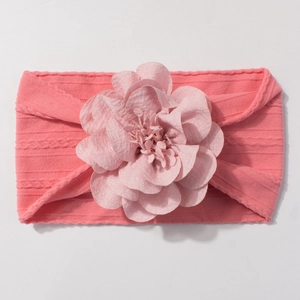 Bandeau bébé en nylon jacquard rose avec une grande fleur faite main sur fond blanc