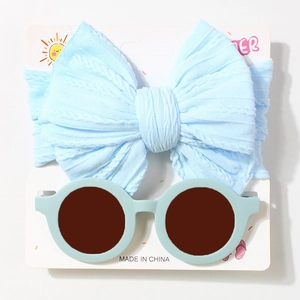 Detail of light blue waffle knit bow headband and matching round sunglasses for babies