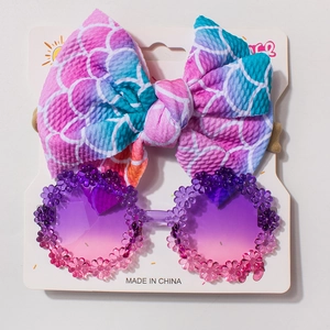 Detail of mermaid scale headband and floral sunglasses set for toddlers on a display card