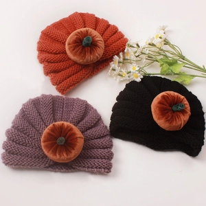 Detailed knit texture of pumpkin-themed baby turban hats in orange, purple and black