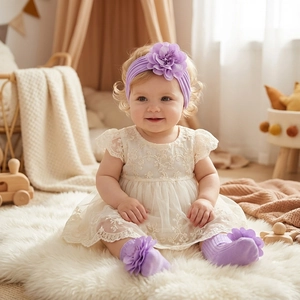 Infant lace dress with floral headband and socks set on soft white nursery rug