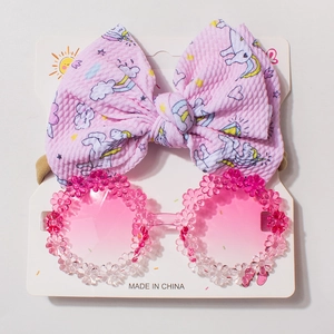 Pink floral frame sunglasses and matching unicorn bow headband on display card