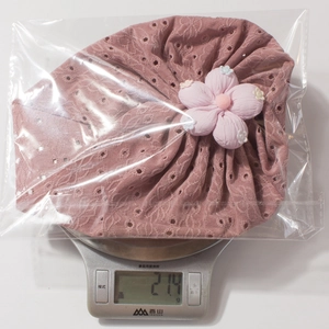 Detailed view of lightweight lotus pink lace baby hat showing its 21.4g ultra-light weight