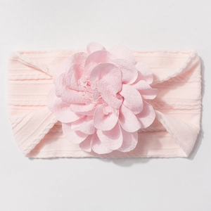 Détail d'un bandeau rose clair pour bébé avec grande fleur en mousseline et tricot côtelé
