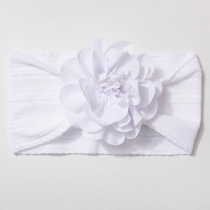 Détail d'un bandeau blanc pour bébé en nylon avec un grand ornement floral en 3D
