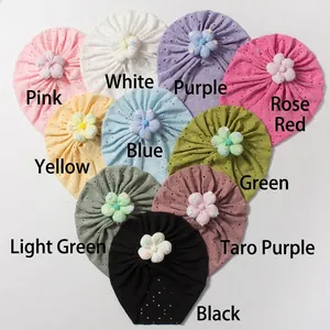 Macro detail of baby knot hats featuring hollow lace fabric and 3D floral decorations