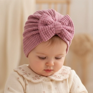 Détail du bonnet turban bébé montrant la maille gaufrée et le grand nœud souple