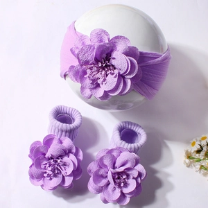 Detail of baby headband and socks set in purple rib knit with large 3D fabric flowers