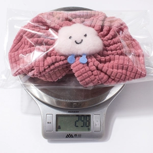 Pink waffle texture baby headband with a plush cloud on a digital scale weighing 29.8g