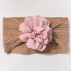 Détail d'un bandeau pour bébé avec bande élastique marron et grande fleur en tissu rose