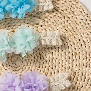 Close-up of soft crochet baby headbands with delicate chiffon flowers in pastel colors