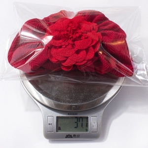 Mesure détaillée du poids d'un accessoire bonnet bébé fleur rouge à 37,1g sur balance