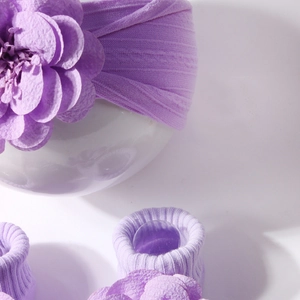 Detail of baby headband and socks set with 3D purple flower and ribbed knit texture