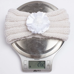 Detail shot showing the lightweight 26.2g knit baby headband with a large fabric flower