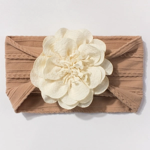 Détails du bandeau bébé en maille camel orné d'une grande fleur en mousseline crème