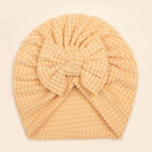 Détail de la texture gaufre et du grand nœud sur le bonnet turban doux pour bébé