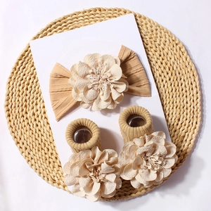 Detail of baby headband and socks set with 3D floral petals on khaki ribbed fabric