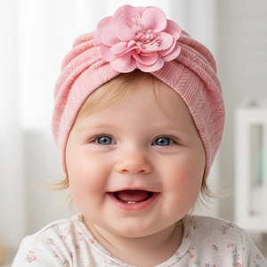 Détail du bonnet turban rose pour bébé avec texture tricotée et grande fleur en tissu