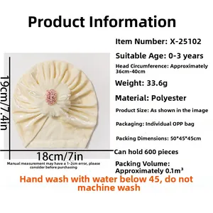 Detail view of cream velvet baby turban with soft tulle flower and sizing specifications