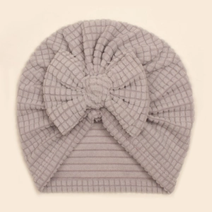 Détail du turban pour bébé en gaufre gris-mauve avec une grande décoration de nœud