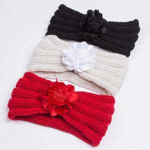 Detailed macro view of three knitted baby headbands with handmade 3D floral decorations