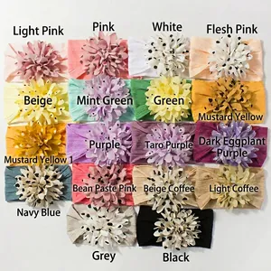 Detail view of 18 colorful jacquard nylon baby headbands with large fabric flowers