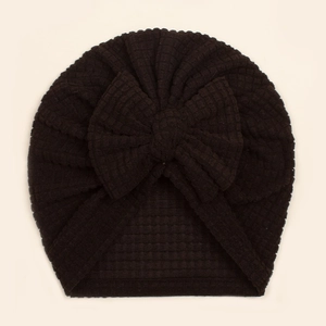 Détail du bonnet turban bébé noir avec texture gaufrée et grand nœud décoratif
