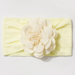 Détail d'un bandeau élastique pour bébé jaune clair avec une grande fleur en mousseline