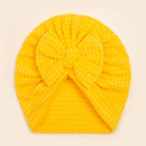 Détail du bonnet turban jaune vif pour bébé en maille gaufrée avec un grand nœud doux