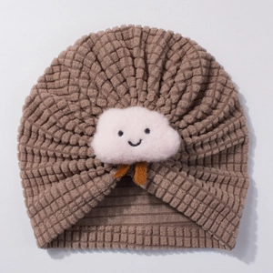 Close-up of baby turban hat featuring brown corn kernel fabric and cute white cloud decor