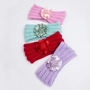Detail of four-color knitted baby headbands with large fabric flowers on white background