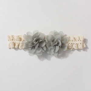 Detail of baby lace headband featuring grey-blue chiffon flowers and cream crochet texture