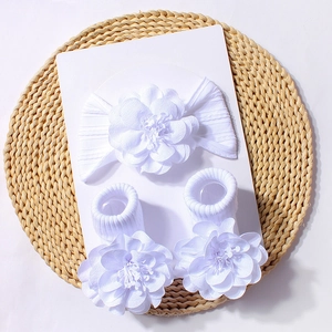 Detailed macro view of white baby floral headband and sock set with handmade flowers