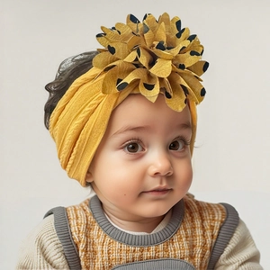 Close-up of bright yellow nylon baby headband featuring a large polka dot flower ornament