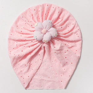 Detail view of pink baby turban hat featuring breathable eyelet fabric and a large 3D flower