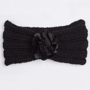 Detailed close-up of a black knitted winter headband for babies with a large floral decoration