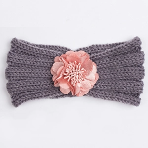 Detail of grey knitted baby headband with decorative pink fabric flower embellishment
