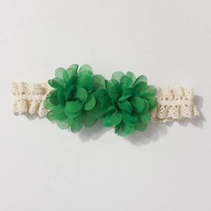 Detailed view of handmade lace baby headband with emerald green chiffon flower petals
