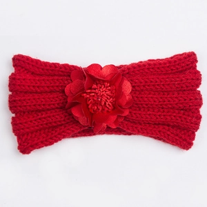 Detailed macro view of a red knitted baby headband featuring a large satin flower ornament